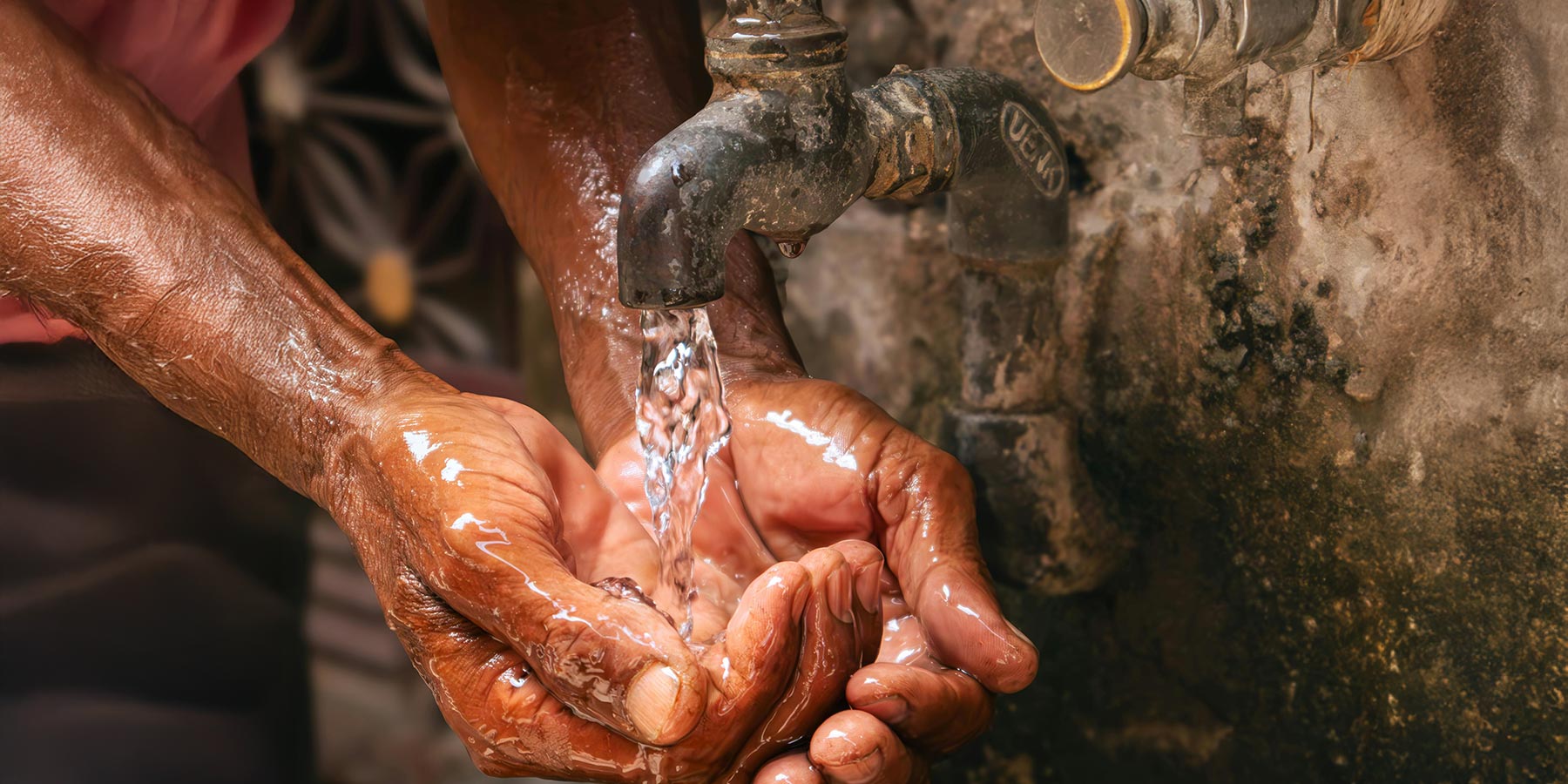 Photo of running hands under an outdoors tap