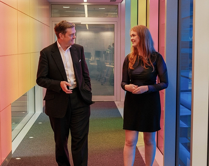 two people walking down a corridor