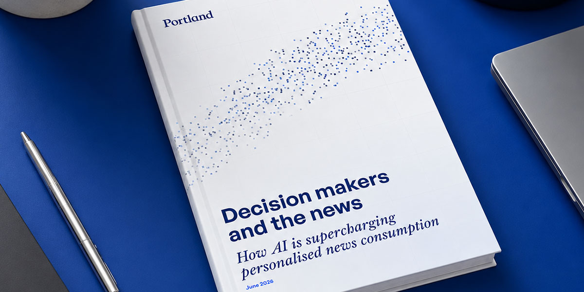 Portland report titled Decision makers and the news placed on a clean modern blue desk, alongside a laptop, pen, desk lamp and potted plant.